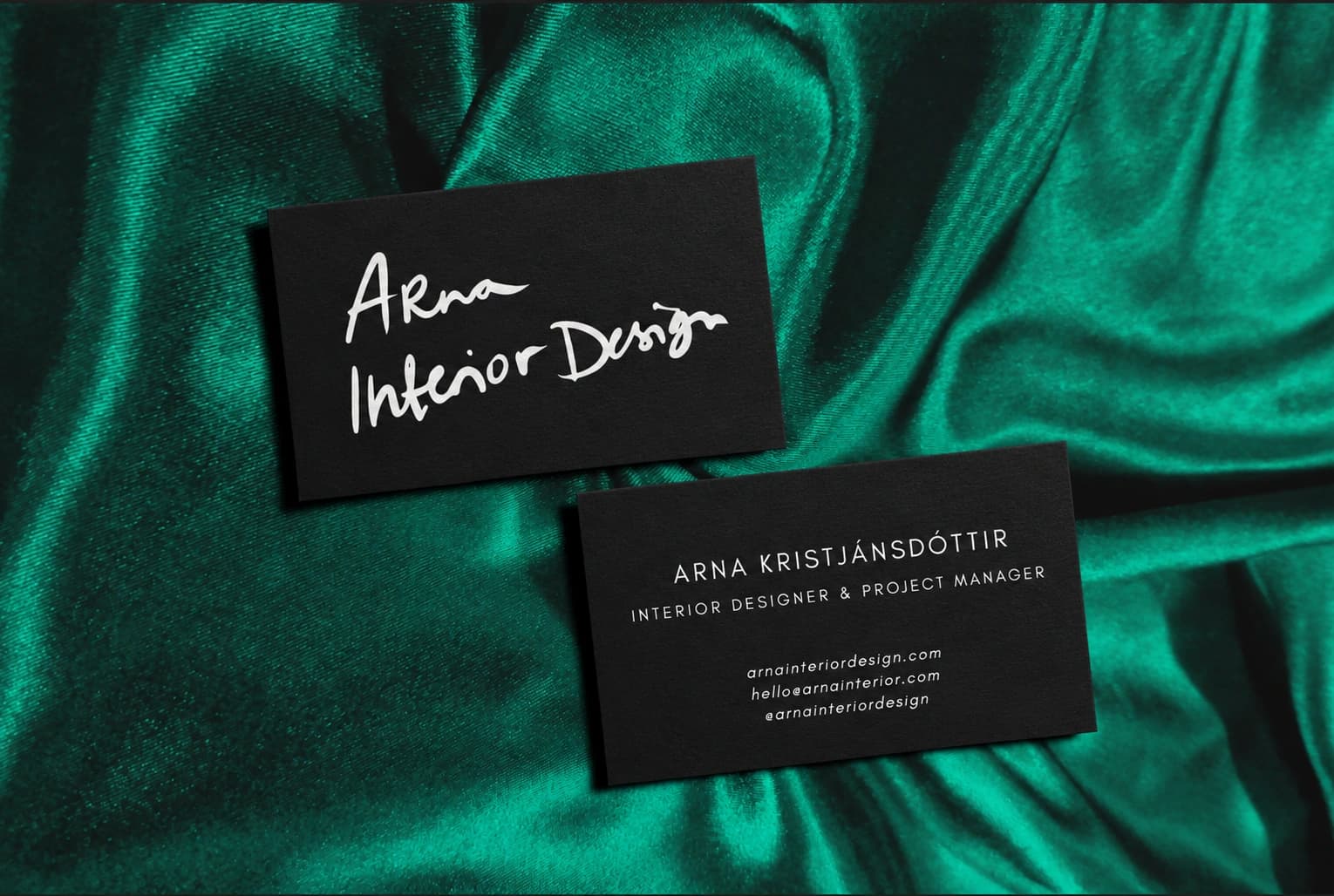 Arna Interior Design business cards on green satin