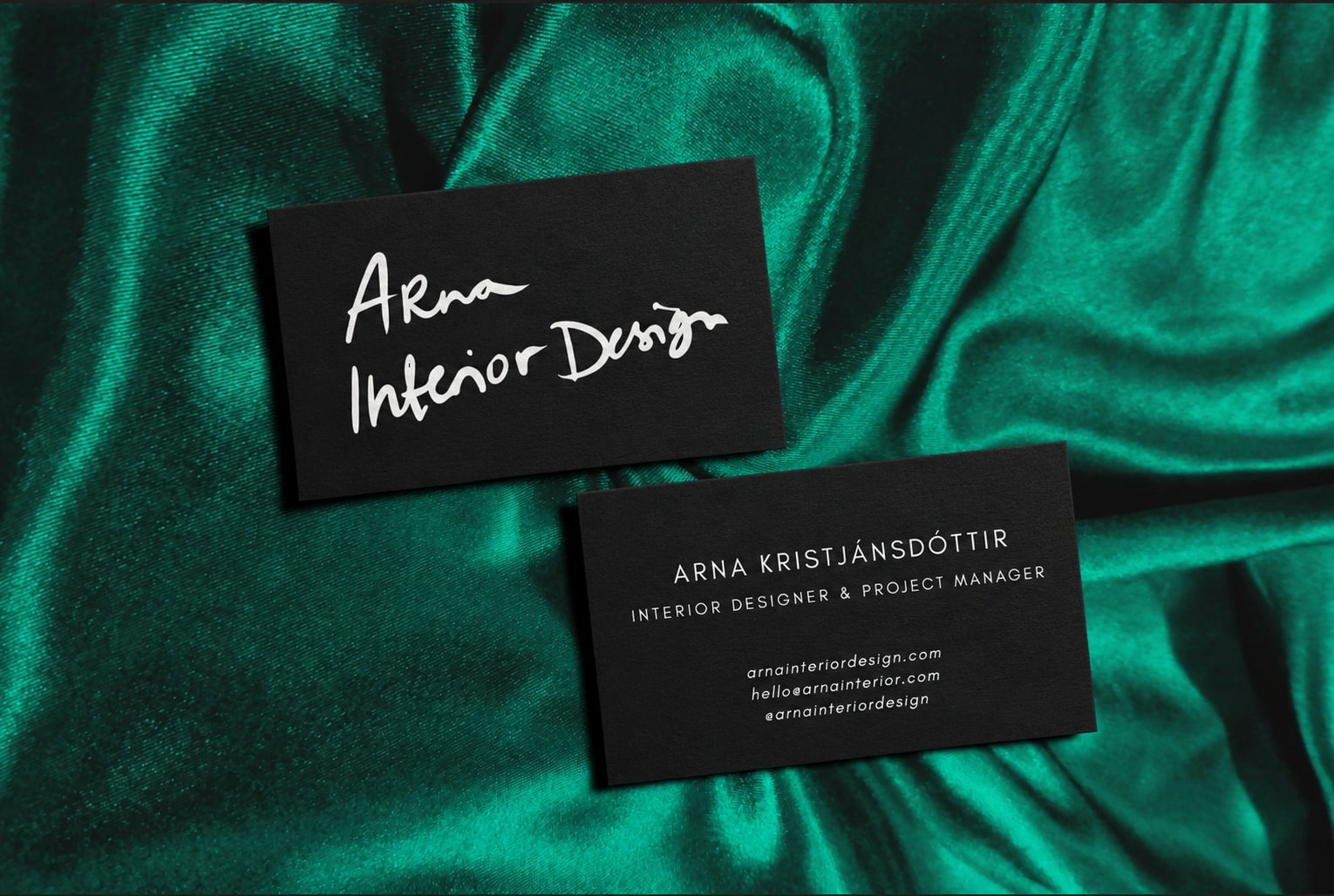 Arna Interior Design business cards on green satin