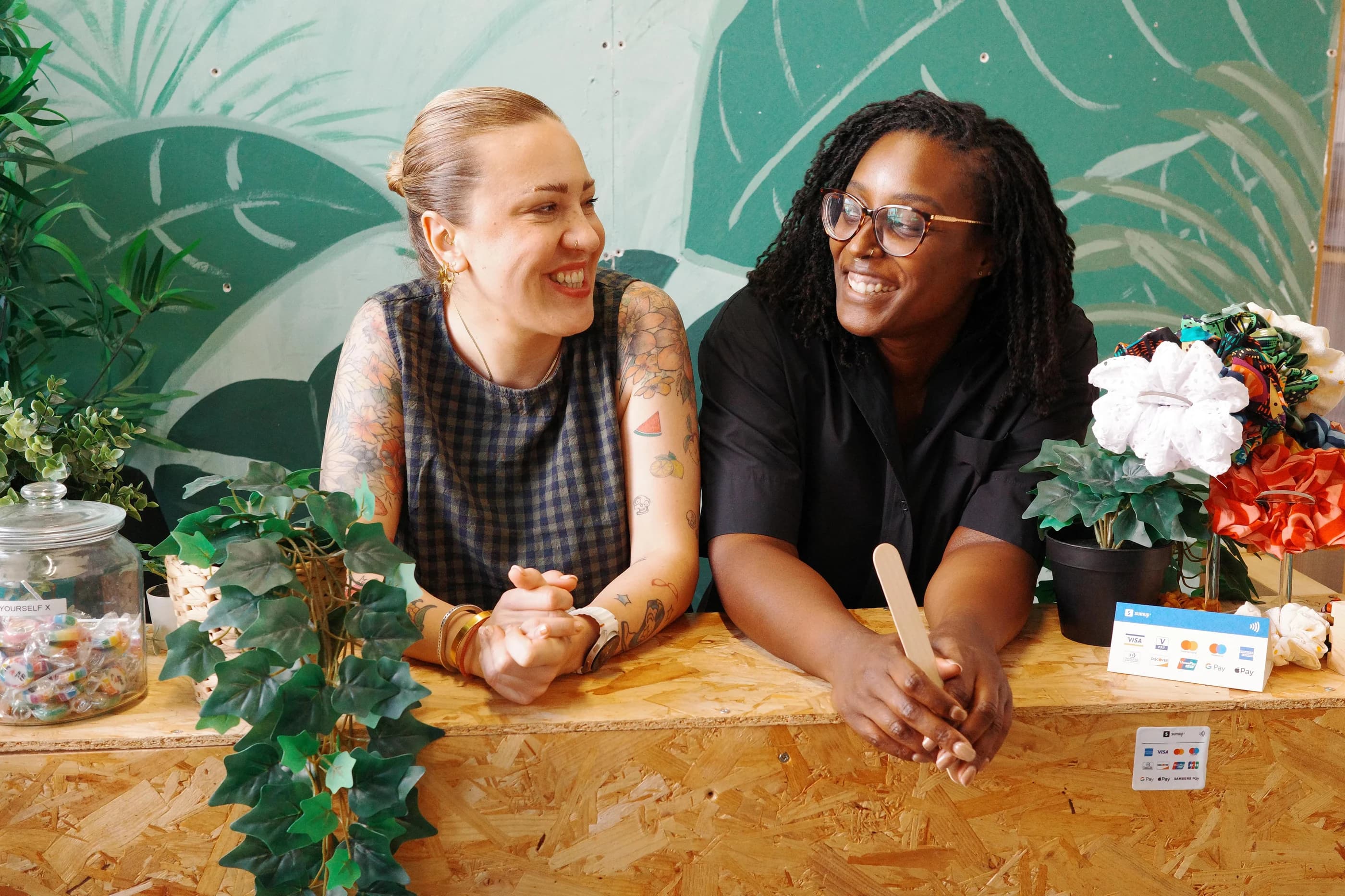 The two founders of Wax Pot London laughing behind the reception desk